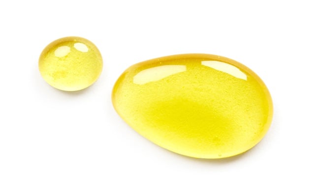 2 yellow oils drops on a white background